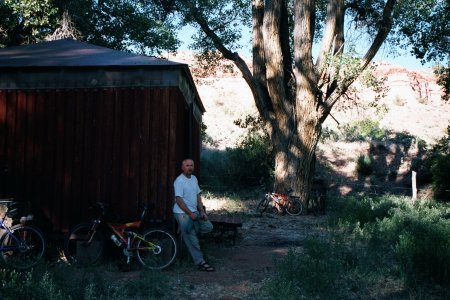 Rob leaning against Gateway Hut, both in shadow.